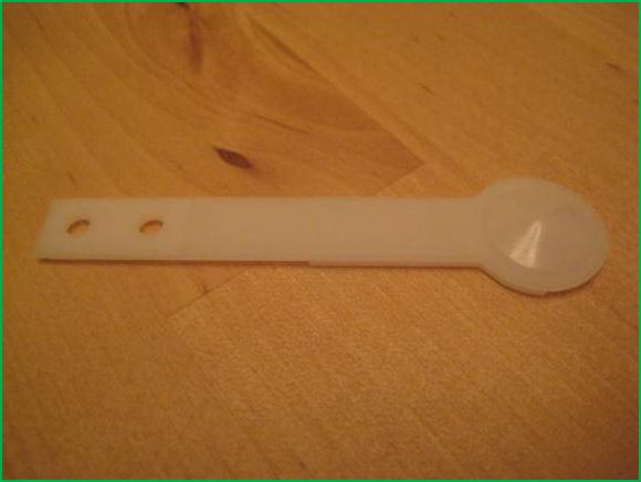 The flat end of this plastic pop bumper spoon can be cleverly used as a Flipper Shaft End Play Spacing Gauge