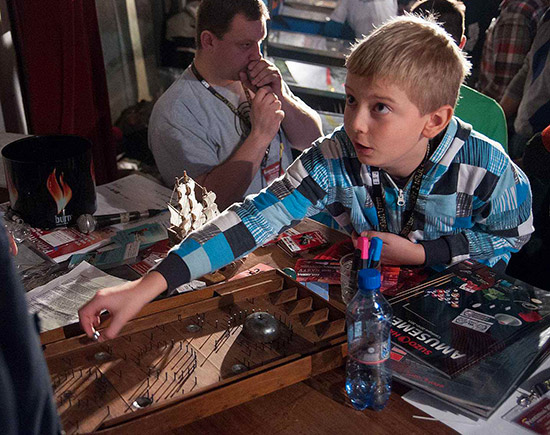 An old game with young player - bagatelle and Mateusz on the organization desk of 11th Polish Pinball Championships