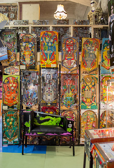The seat is located in front of a wall of pinball playfields