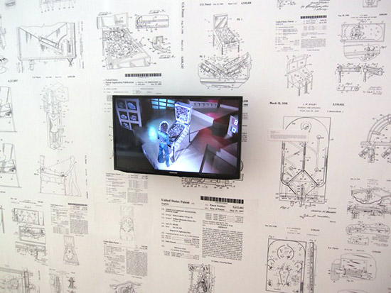 A wall with pinball machine diagrams and a video from the movie Tommy