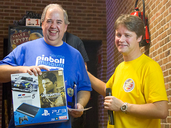 Belgian Open Pinball winner, Martin Ayub is presented with his prize of a Sony Playstation 3 bundle by Lieven 