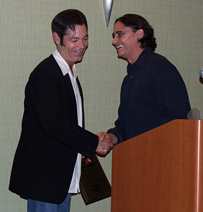 Kevin presents George with his plaque