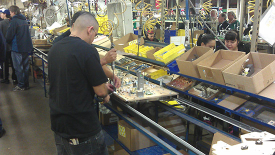 Each workstation adds more to the playfield, with assemblies being made on workstations on the other side of the line